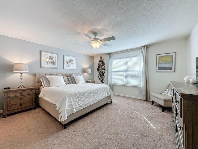 bedroom with light carpet, ceiling fan, and a textured ceiling