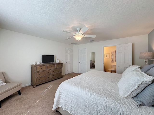 bedroom featuring a textured ceiling, ceiling fan, carpet, and connected bathroom