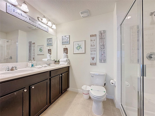 bathroom with a textured ceiling, an enclosed shower, tile patterned flooring, vanity, and toilet