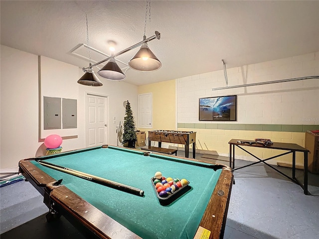 playroom featuring a textured ceiling, concrete flooring, electric panel, and billiards