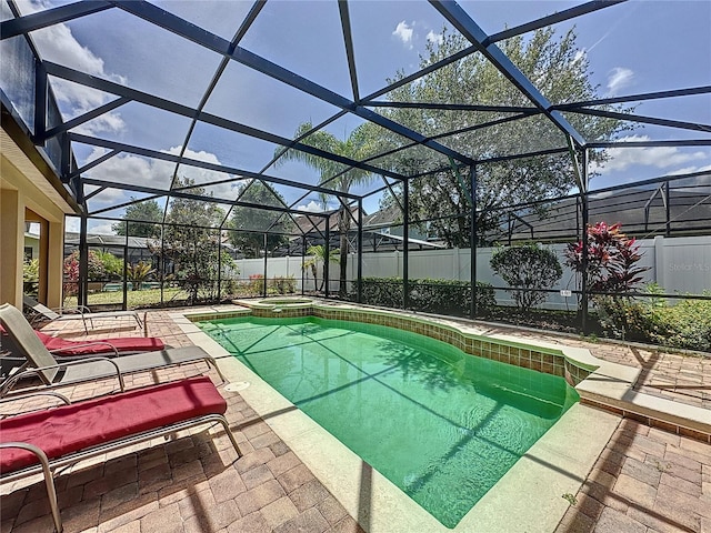 view of pool featuring a lanai, a patio area, and an in ground hot tub