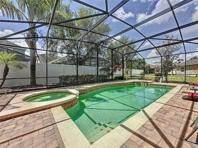 view of pool featuring glass enclosure, an in ground hot tub, and a patio