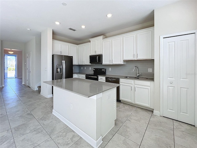 kitchen with white cabinetry, sink, black electric range oven, stainless steel fridge, and a kitchen island