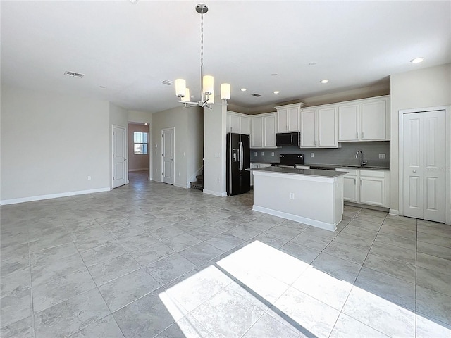 kitchen with tasteful backsplash, sink, black appliances, a chandelier, and white cabinetry