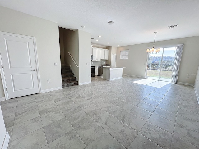 unfurnished living room with a chandelier