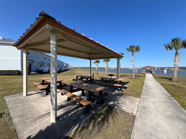 view of property's community with a lawn, a water view, and a gazebo