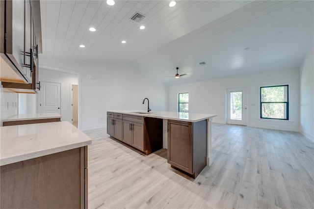 kitchen with wood ceiling, light hardwood / wood-style floors, ceiling fan, a kitchen island with sink, and sink