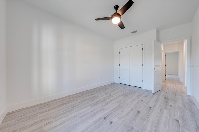 unfurnished bedroom with ceiling fan, a closet, and light wood-type flooring