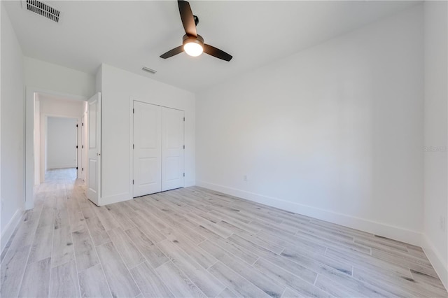 unfurnished bedroom with ceiling fan, a closet, and light hardwood / wood-style floors