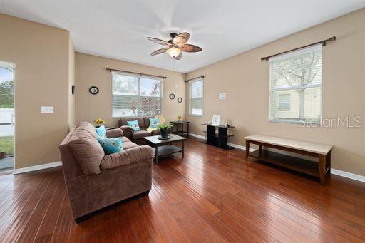 living room with ceiling fan and dark hardwood / wood-style floors