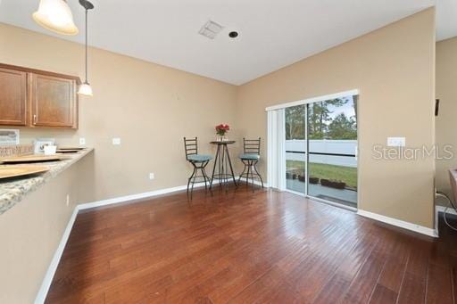 interior space with decorative light fixtures and dark hardwood / wood-style floors