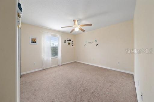 empty room with light carpet and ceiling fan