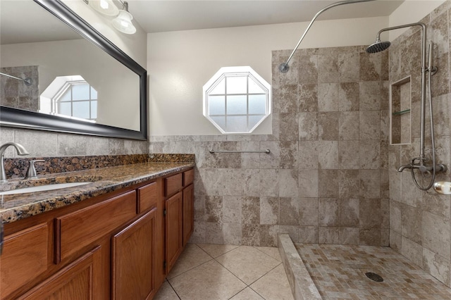 bathroom featuring tile patterned floors, vanity, and a tile shower