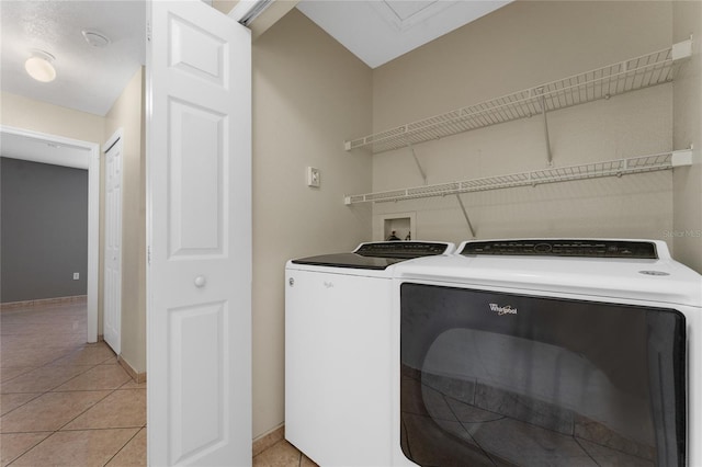 laundry room with light tile patterned floors and washing machine and dryer