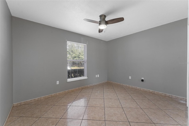 tiled spare room with ceiling fan