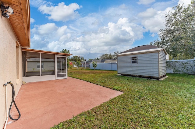 view of yard with a shed, a sunroom, and a patio