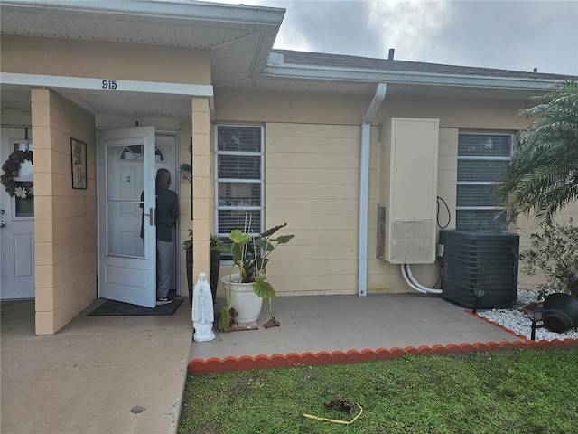 property entrance featuring central AC unit and a patio