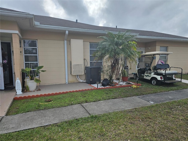 view of front of property featuring a front yard and cooling unit