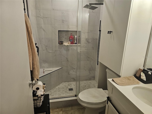 bathroom with a shower with door, vanity, and toilet