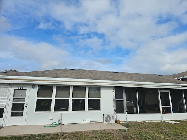 rear view of property with ac unit, a sunroom, and a lawn