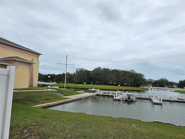 view of dock with a yard and a water view