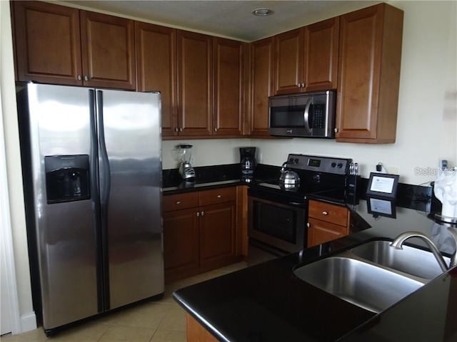 kitchen with sink, stainless steel appliances, and light tile patterned flooring