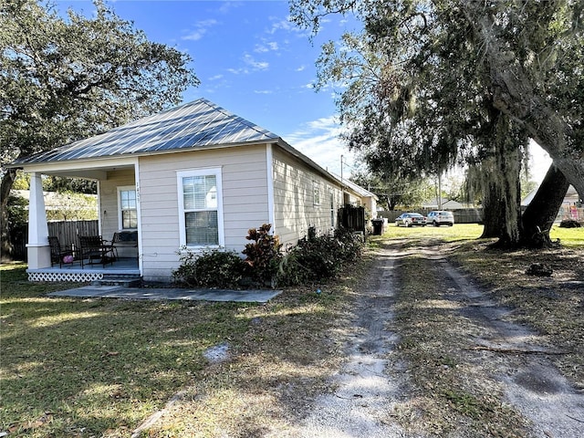 view of property exterior with a yard and covered porch