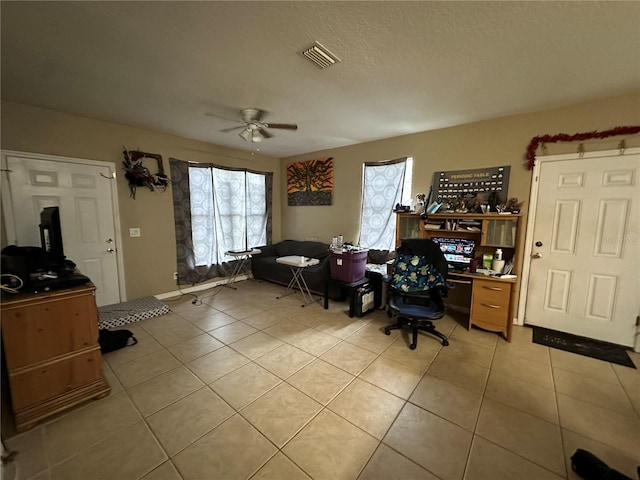 tiled office space with ceiling fan and a textured ceiling