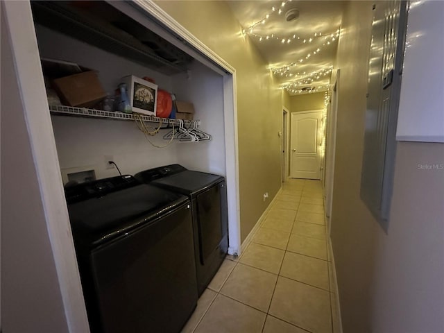 laundry area with washer and dryer and light tile patterned floors