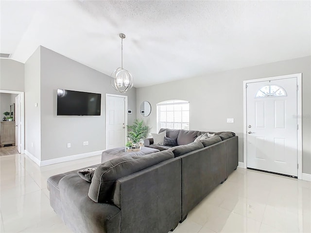 living room with a textured ceiling, an inviting chandelier, vaulted ceiling, and light tile patterned floors