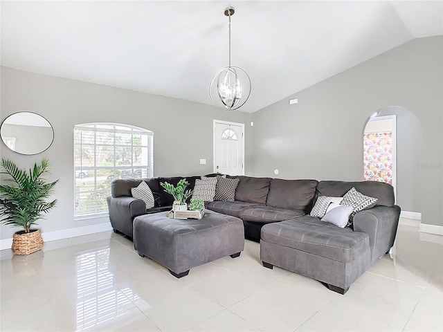 living room with lofted ceiling, an inviting chandelier, and light tile patterned flooring