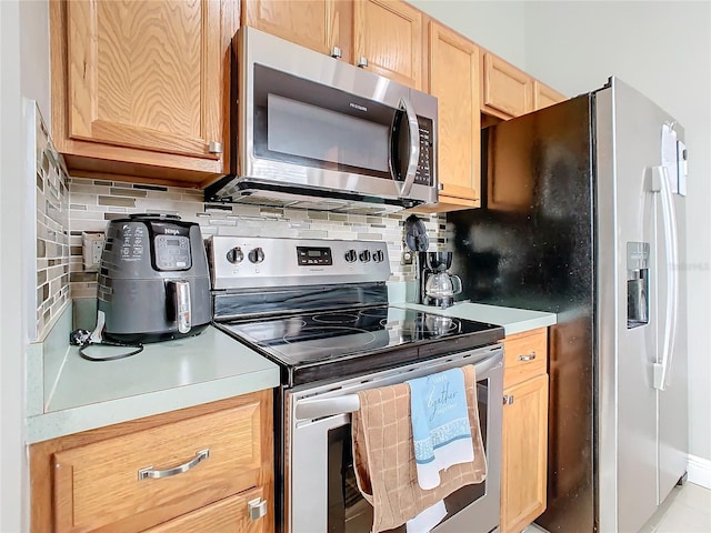 kitchen with stainless steel appliances and tasteful backsplash