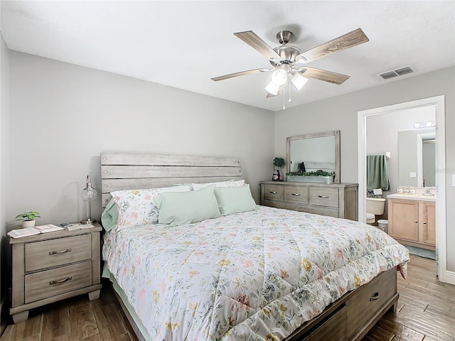 bedroom with wood-type flooring, ensuite bath, and ceiling fan