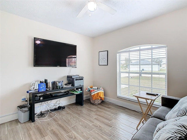 living room featuring ceiling fan, light hardwood / wood-style floors, and plenty of natural light