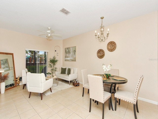 tiled dining area with ceiling fan with notable chandelier and a textured ceiling