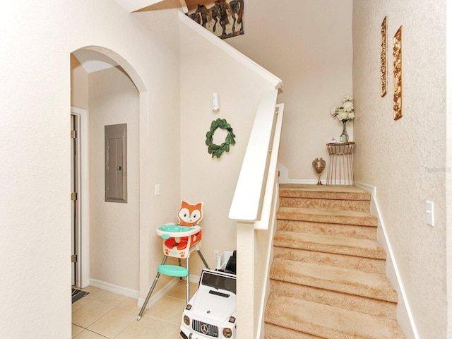 staircase with tile patterned floors and electric panel