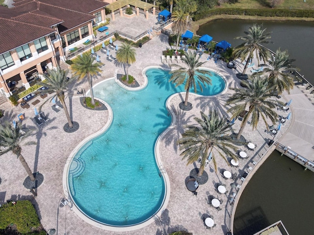 view of swimming pool featuring a patio and a water view