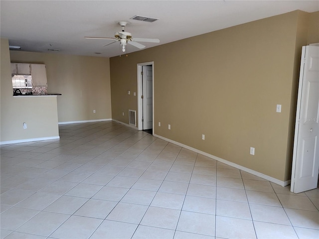 tiled empty room featuring ceiling fan