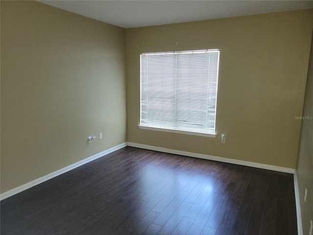 spare room featuring dark wood-type flooring