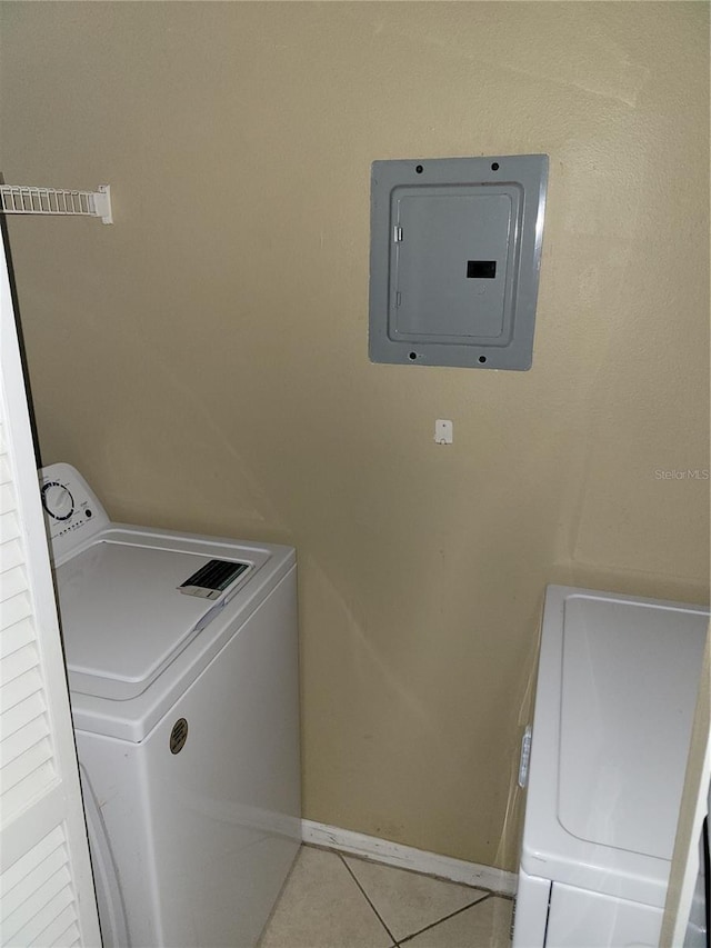 laundry room with electric panel, washer / dryer, and light tile patterned floors