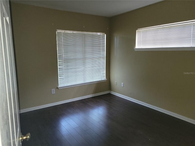 unfurnished room with dark hardwood / wood-style flooring