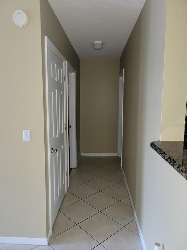 hall with light tile patterned floors