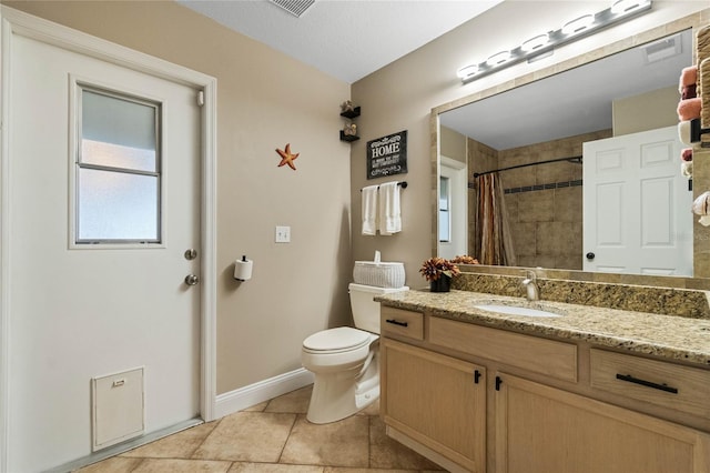 bathroom featuring tile patterned flooring, vanity, toilet, and walk in shower