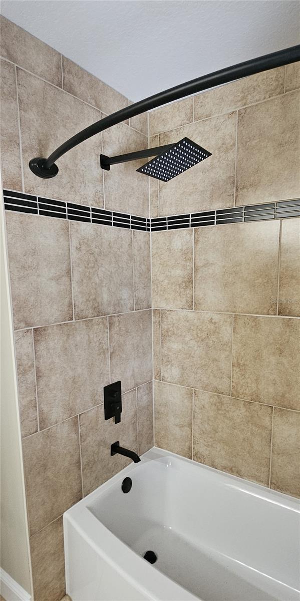 room details featuring tiled shower / bath