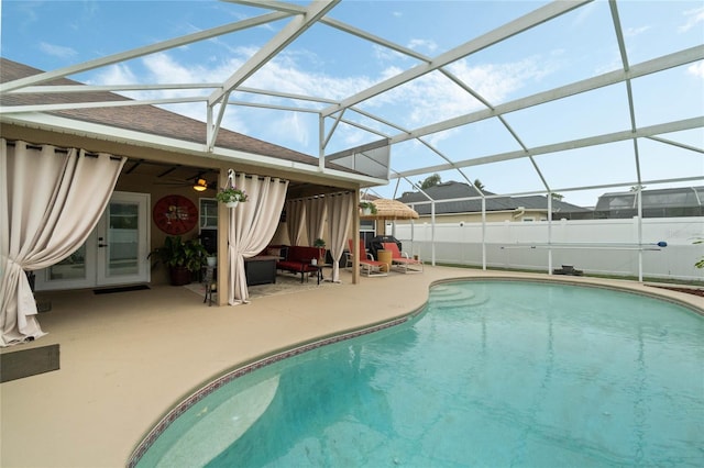 view of pool with glass enclosure and a patio area