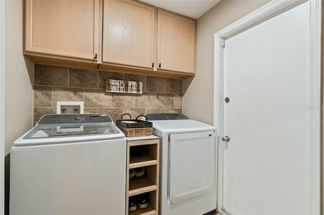 laundry room featuring separate washer and dryer and cabinets