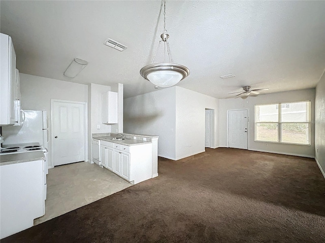 kitchen with ceiling fan, pendant lighting, sink, light carpet, and white cabinets