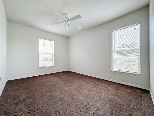 carpeted empty room with ceiling fan and a wealth of natural light