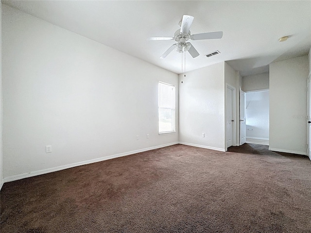 unfurnished room featuring ceiling fan and dark carpet