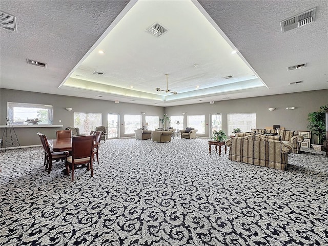 interior space with a textured ceiling and a tray ceiling